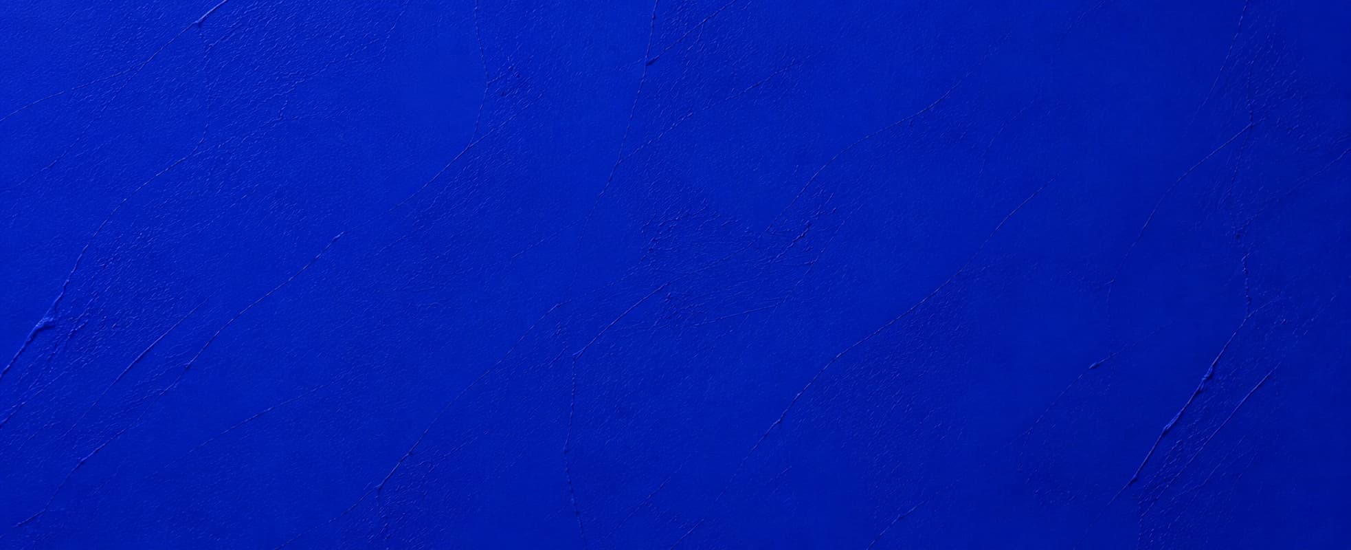 Parede pintada de azul royal, com a textura da tinta à mostra
